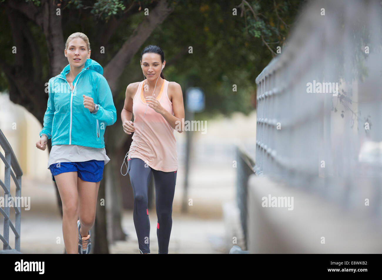 Young Woman In Sports Outfit Jogging In Public Park High-Res Stock