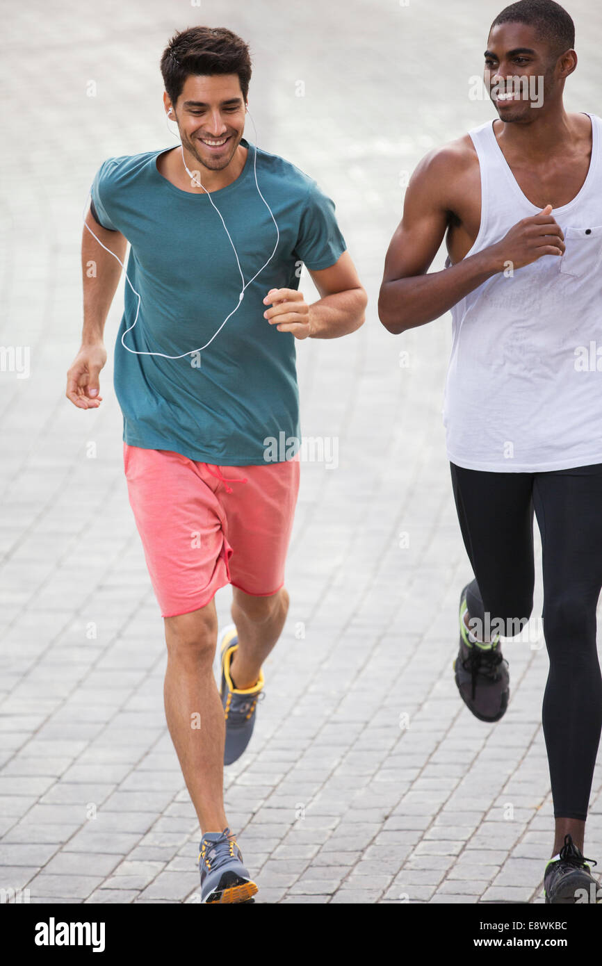 Men running through city streets together Stock Photo