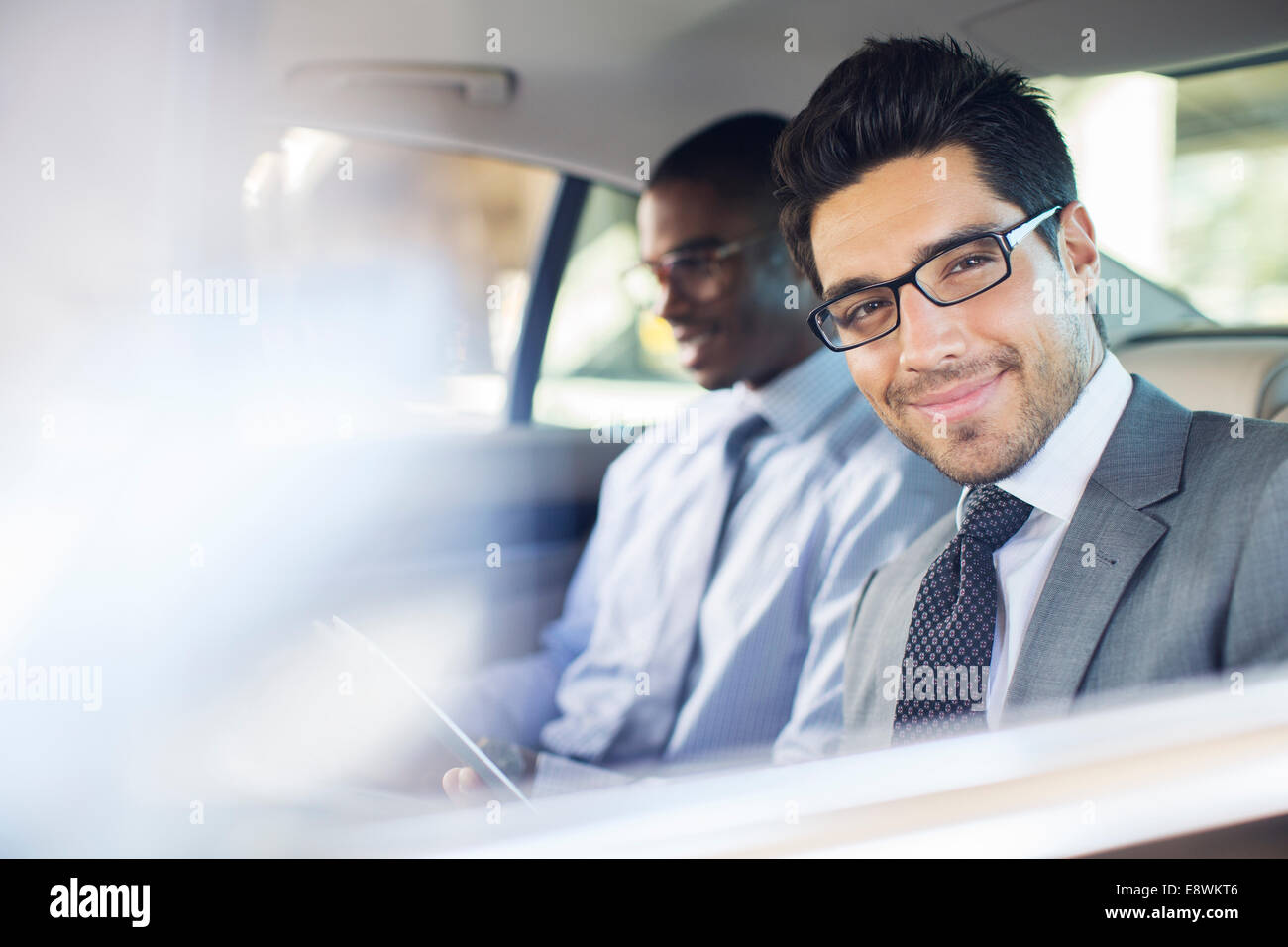 Businessman using digital tablet in car back seat Stock Photo