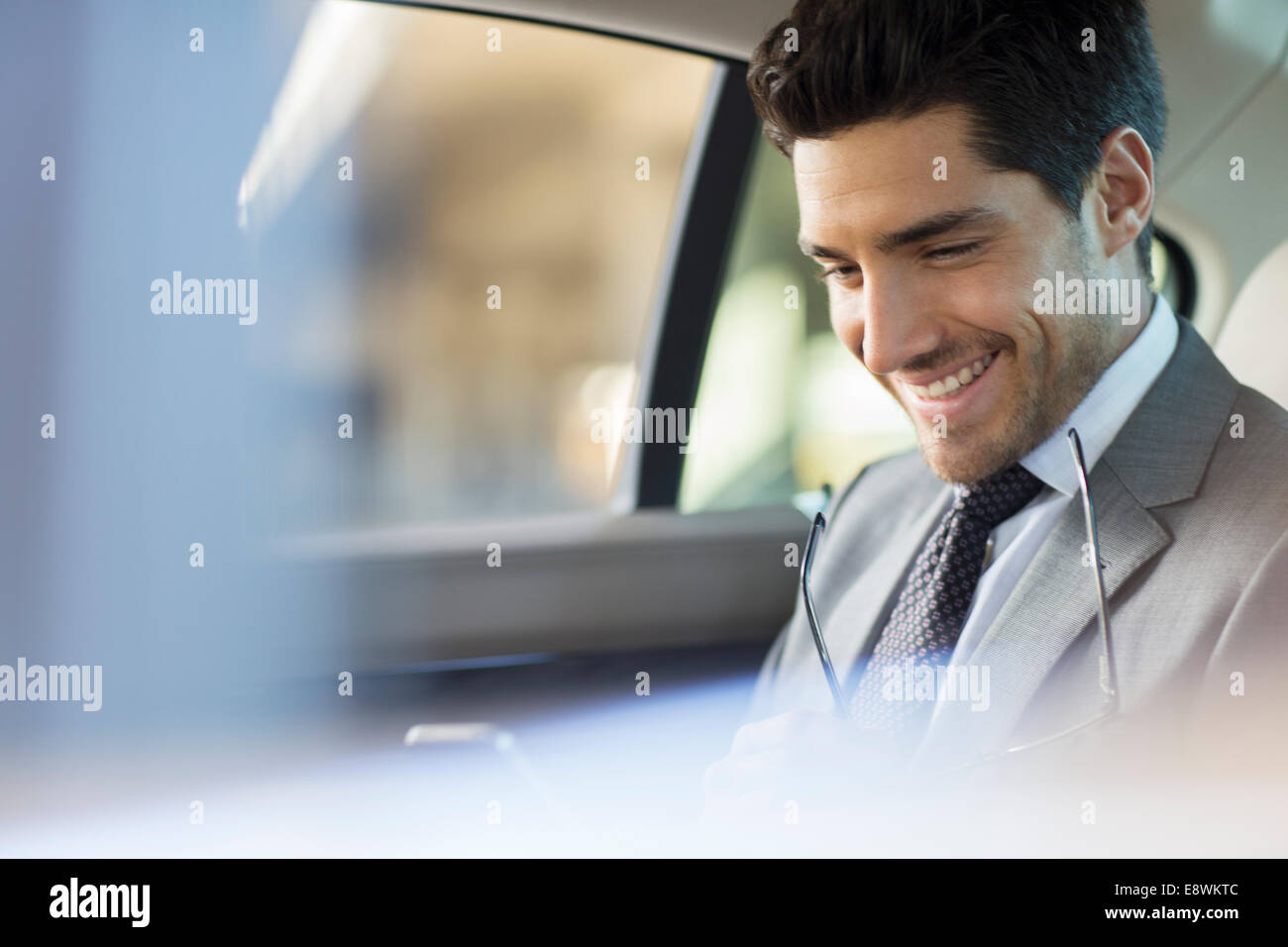 Businessman using cell phone in car back seat Stock Photo