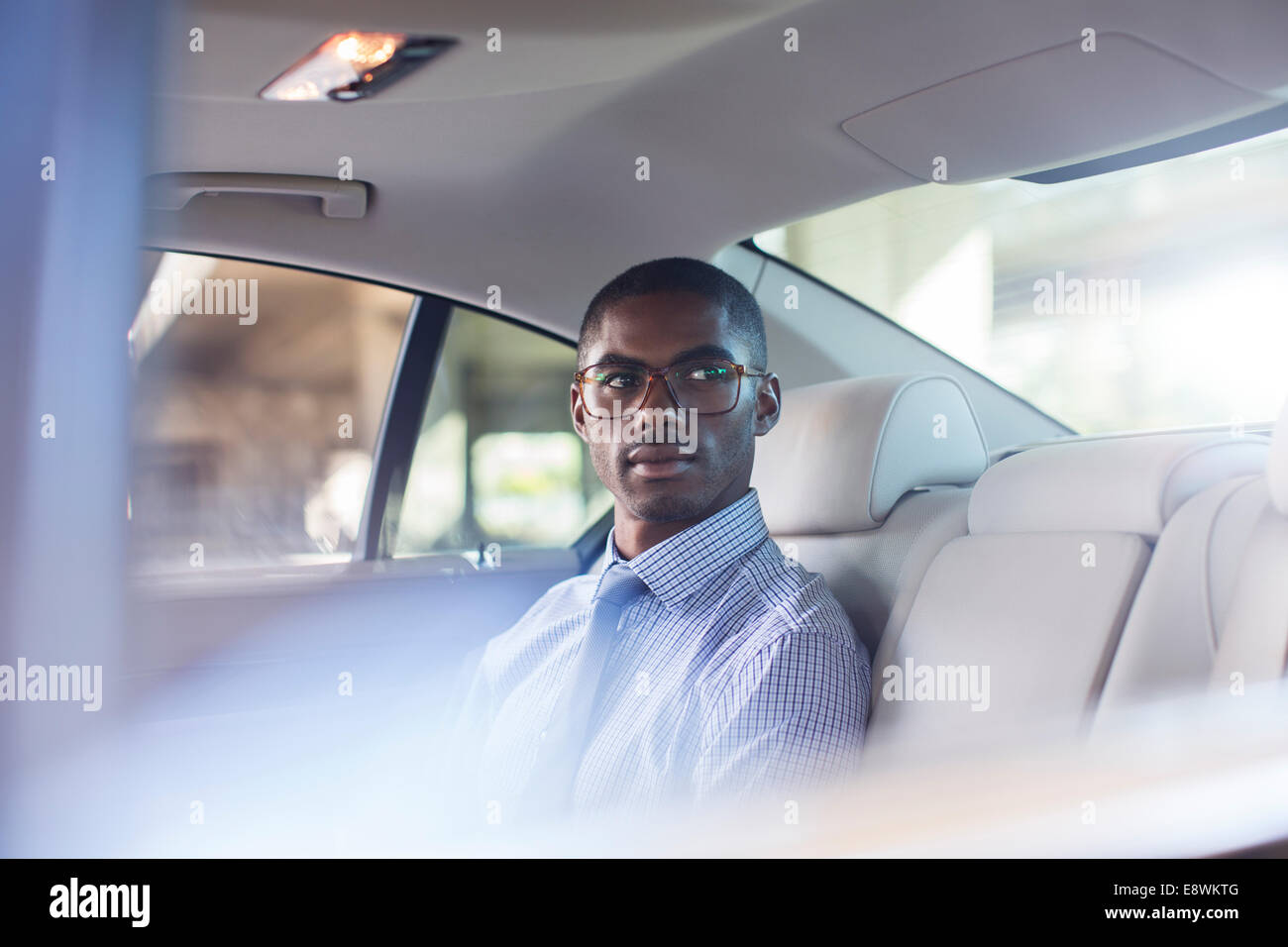 Businessman sitting in car back seat Stock Photo