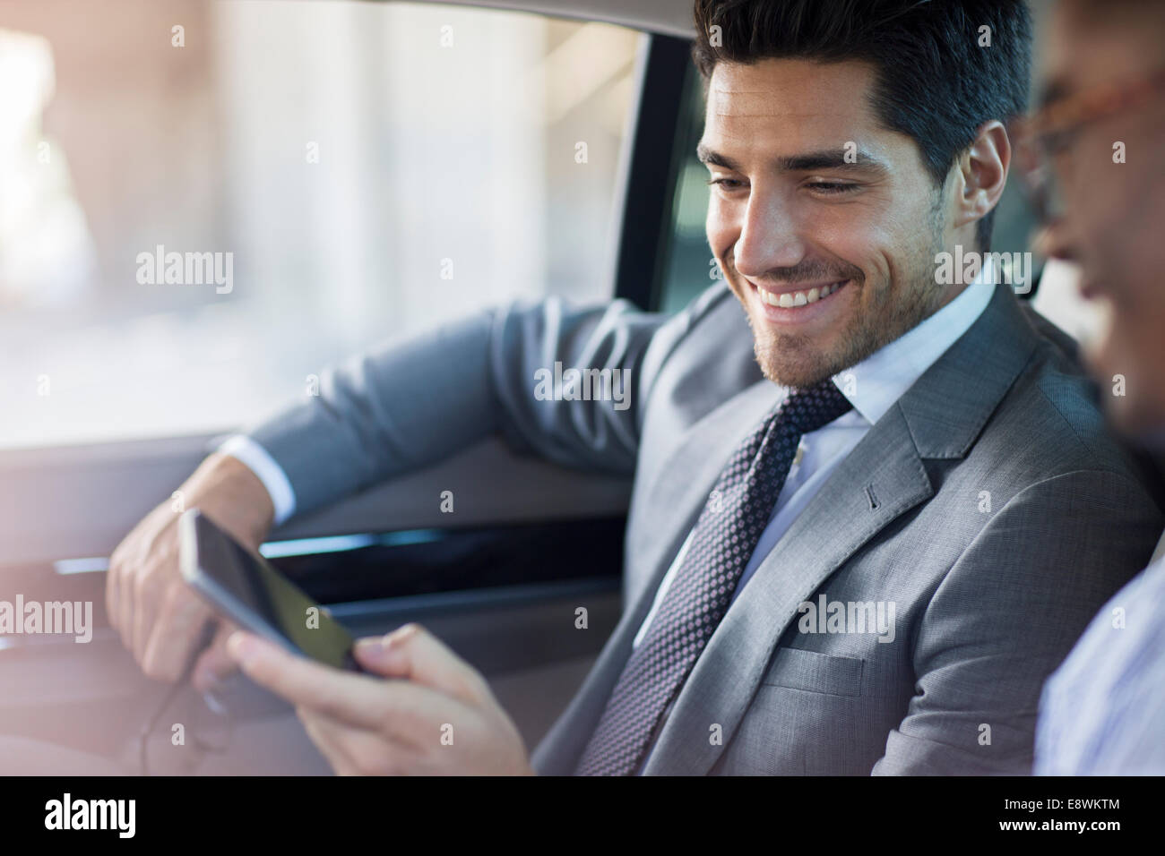 Businessmen looking at cell phone in car Stock Photo