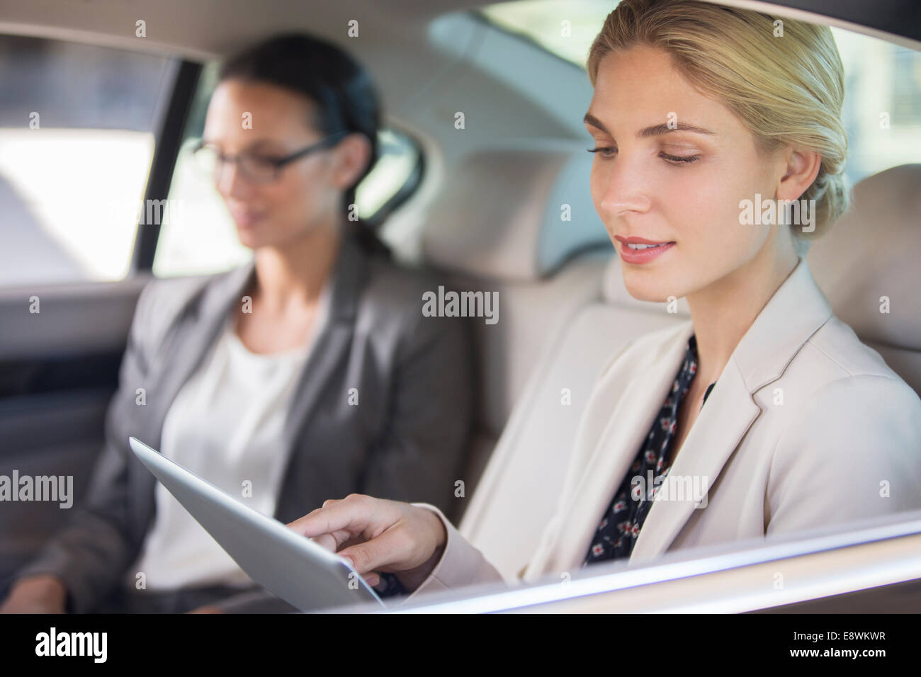 Businesswoman using digital tablet in car back seat Stock Photo