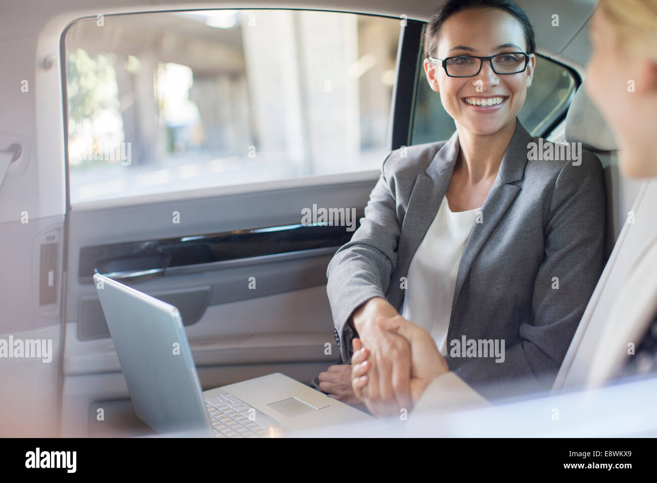 Businesswomen shaking hands in car Stock Photo