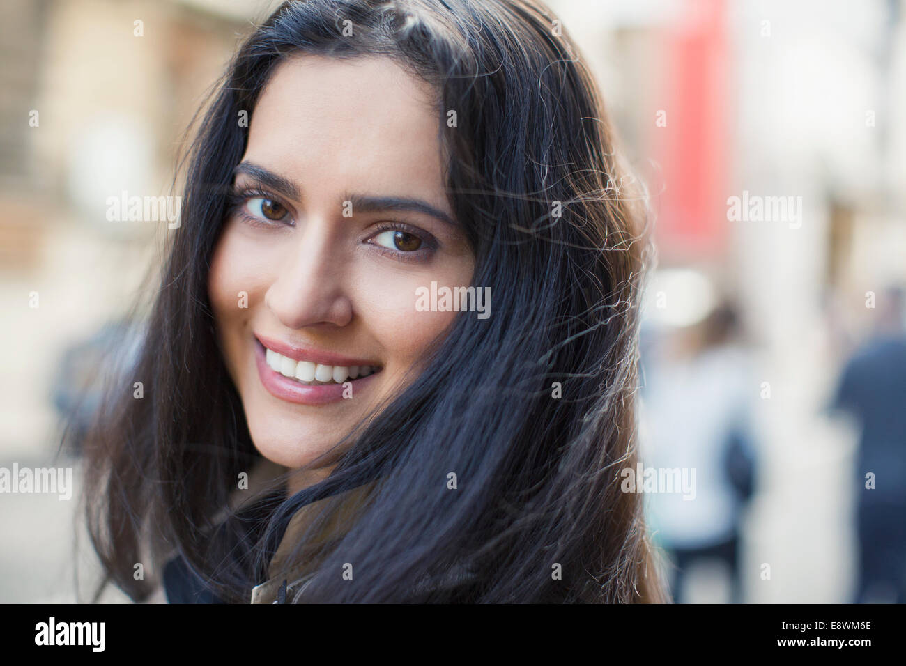 Woman smiling on city street Stock Photo