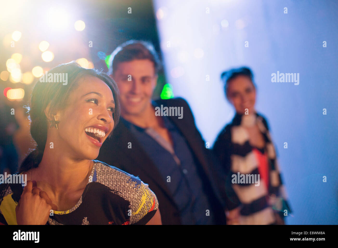 Friends laughing on city street at night Stock Photo - Alamy