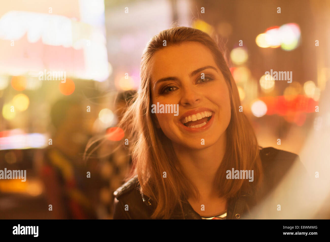Woman smiling on city street at night Stock Photo - Alamy