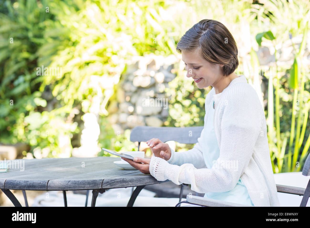Woman using digital tablet at table outdoors Stock Photo
