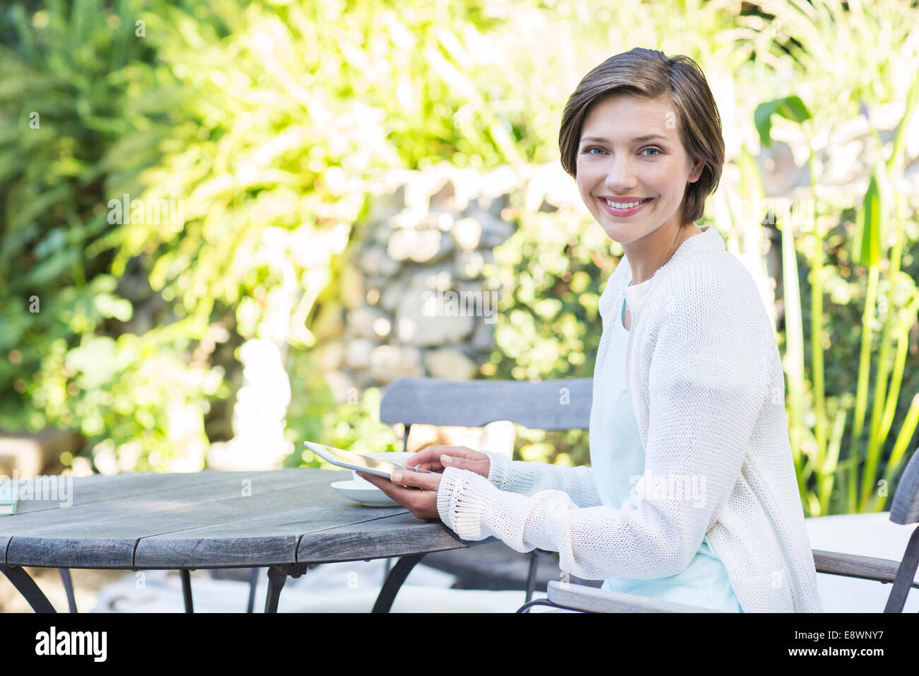 Woman using digital tablet at table outdoors Stock Photo