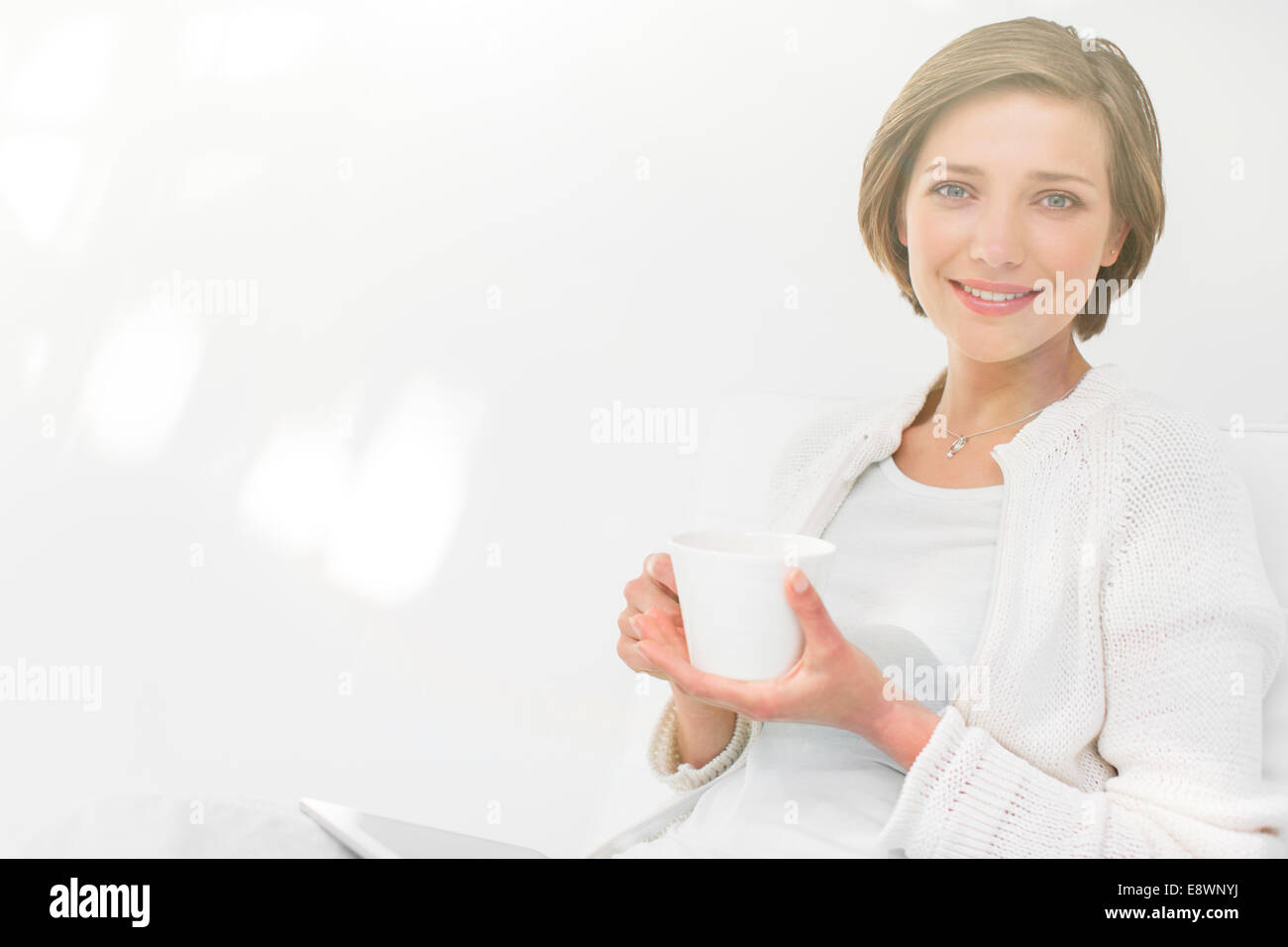 Woman drinking coffee and using digital tablet outdoors Stock Photo