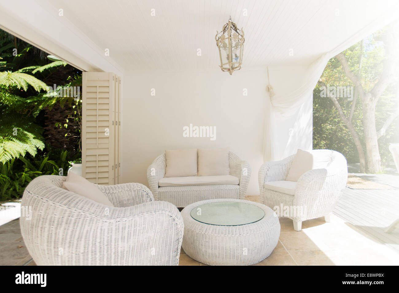 Cat sleeping in outdoor furniture on patio Stock Photo