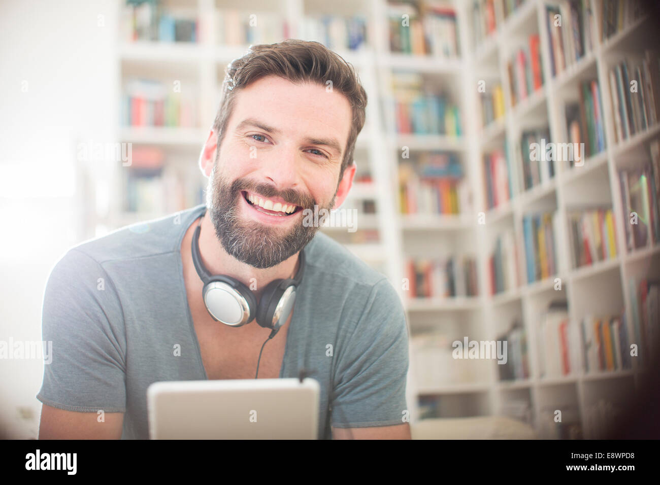 Smiling man using digital tablet in living room Stock Photo