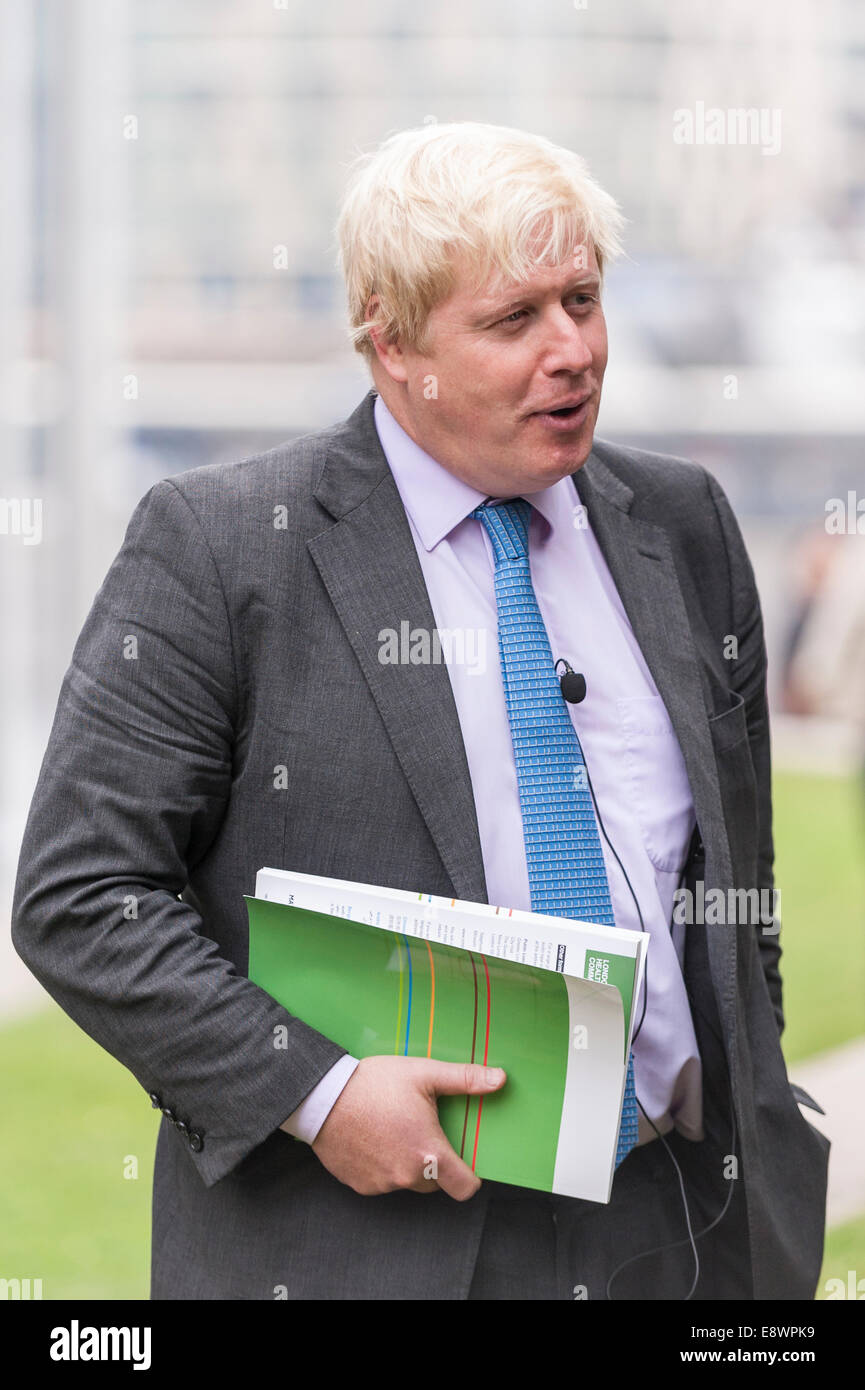 London, UK. 15th October, 2015.  Boris Johnson, Mayor of London, clutching a copy of the report, Better Health for London, arrives to meet London schoolchildren playing football outside City Hall as part of London United.  The citywide initiative involves all 15 London football clubs and encourages youngsters to get more active. Credit:  Stephen Chung/Alamy Live News Stock Photo