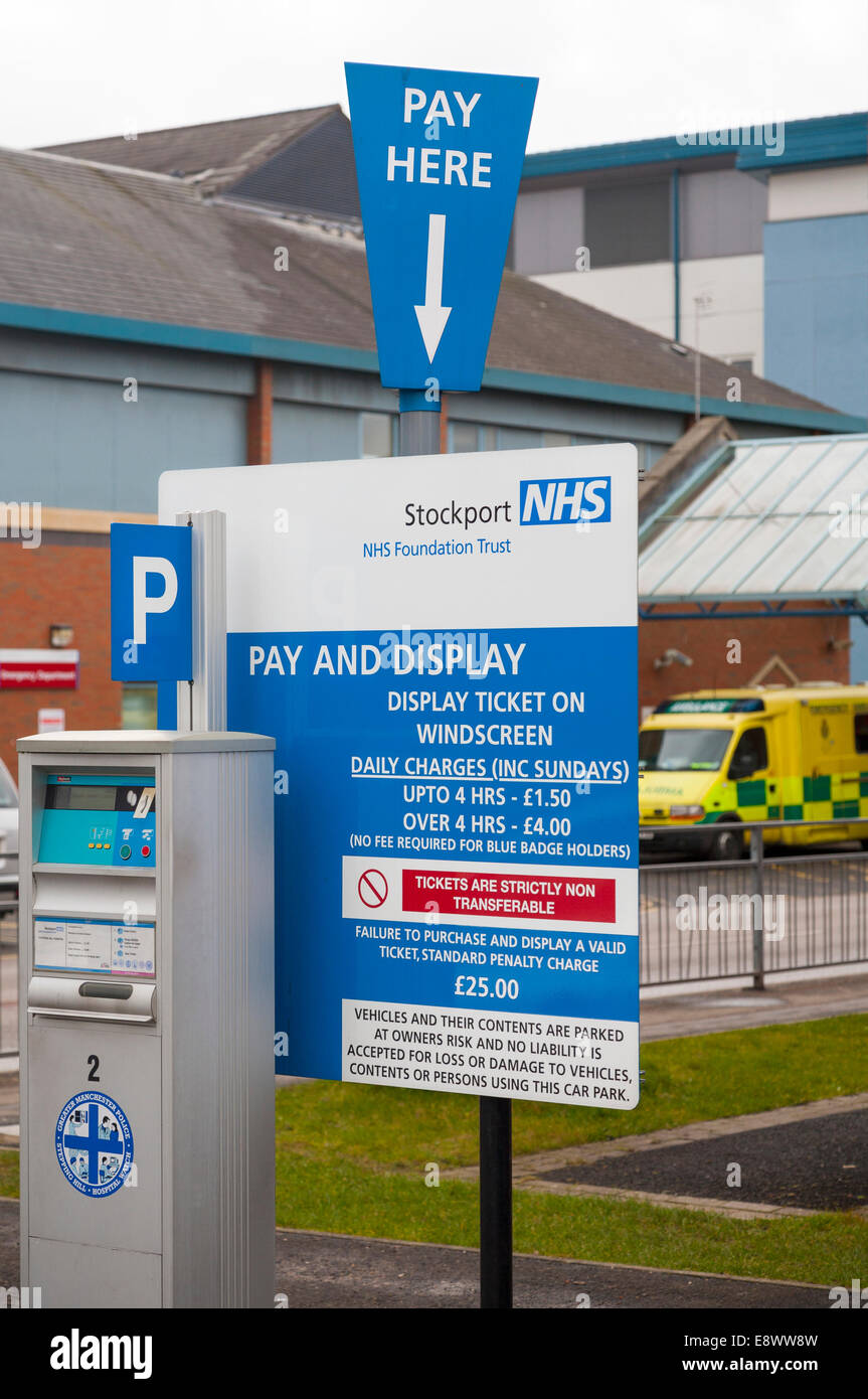 Pay and Display meter to issue tickets, and charges / parking charging rate sign, in an NHS hospital Car Park. UK Stock Photo