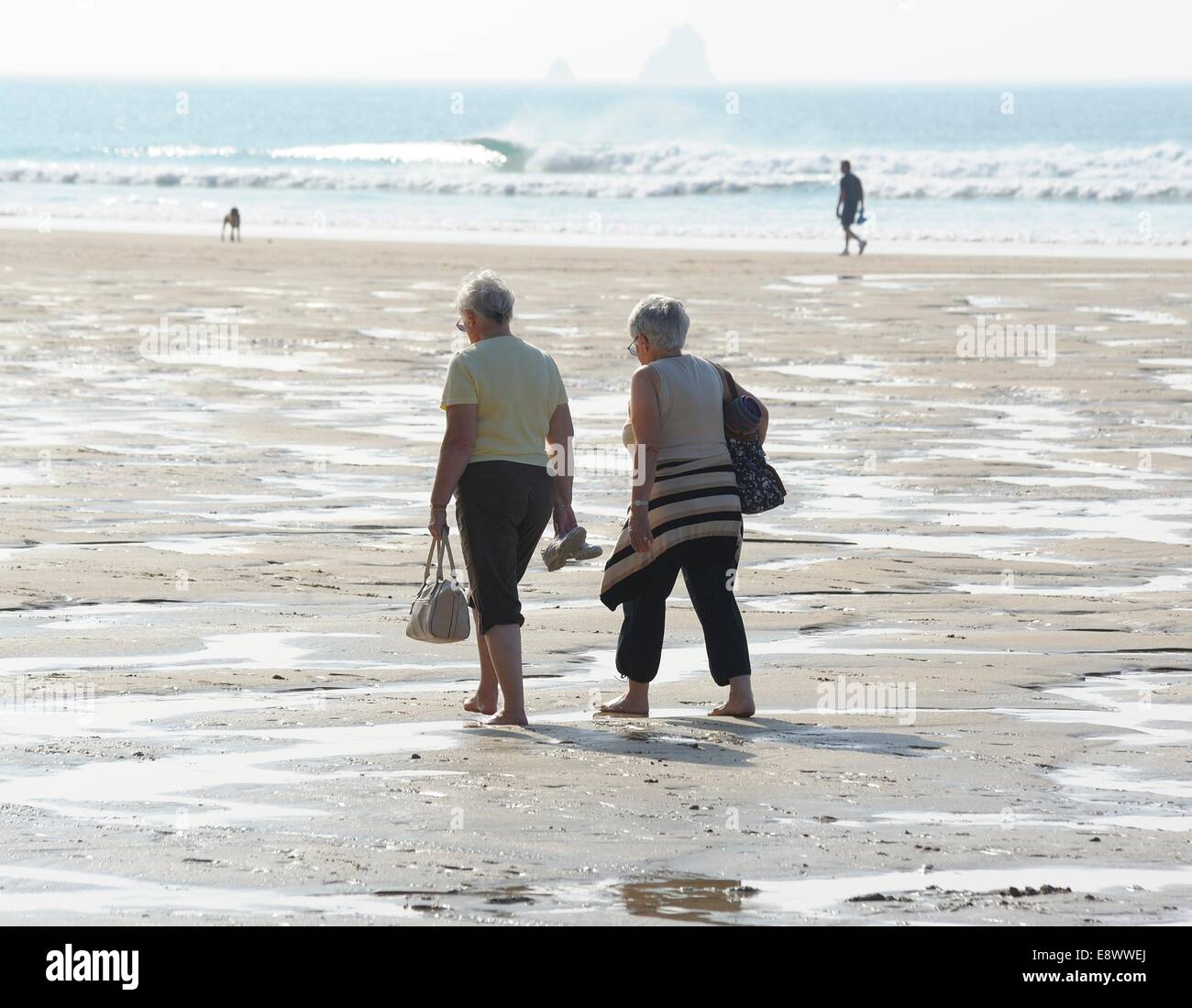 2 Elderly senior woman walking on Penhale beach Perranporth Cornwall England uk Stock Photo