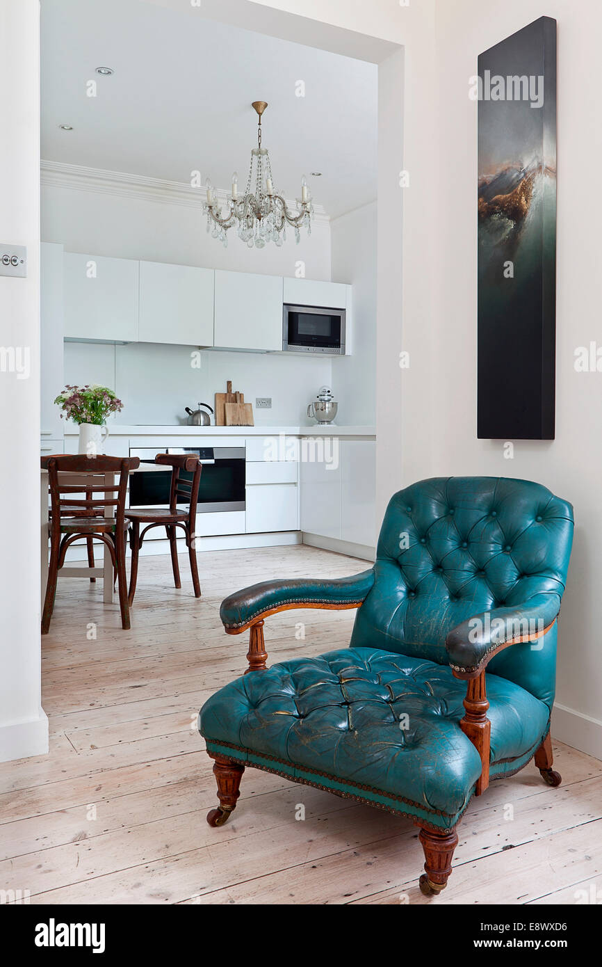 Blue armchair in sitting room with view to modern kitchen, Hove Stock Photo