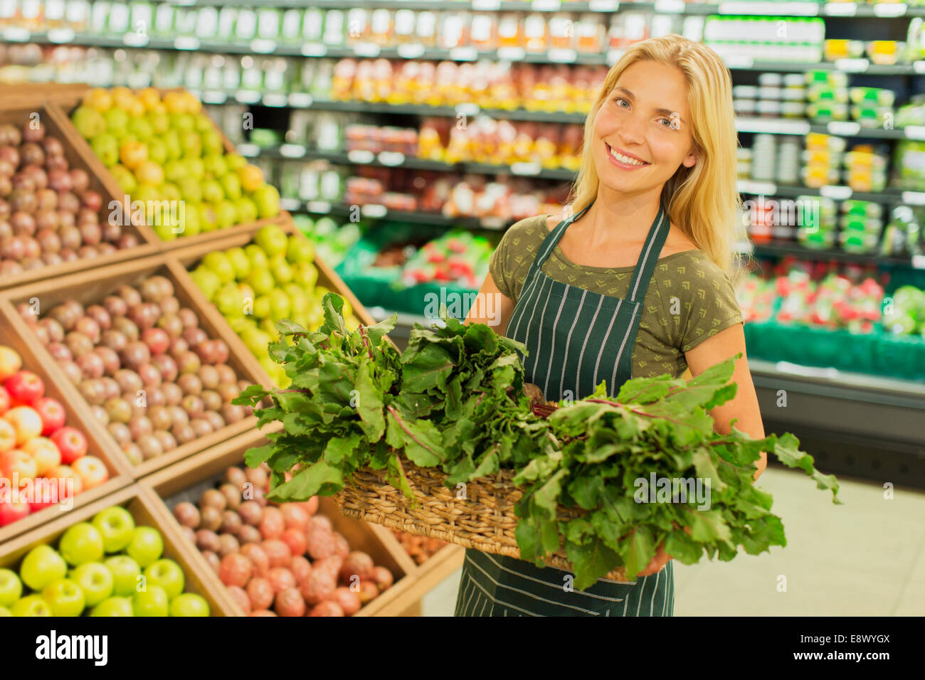 Grocery clerk working in produce aisle of supermarket store Stock Photo by  ©FreeProd 118794062