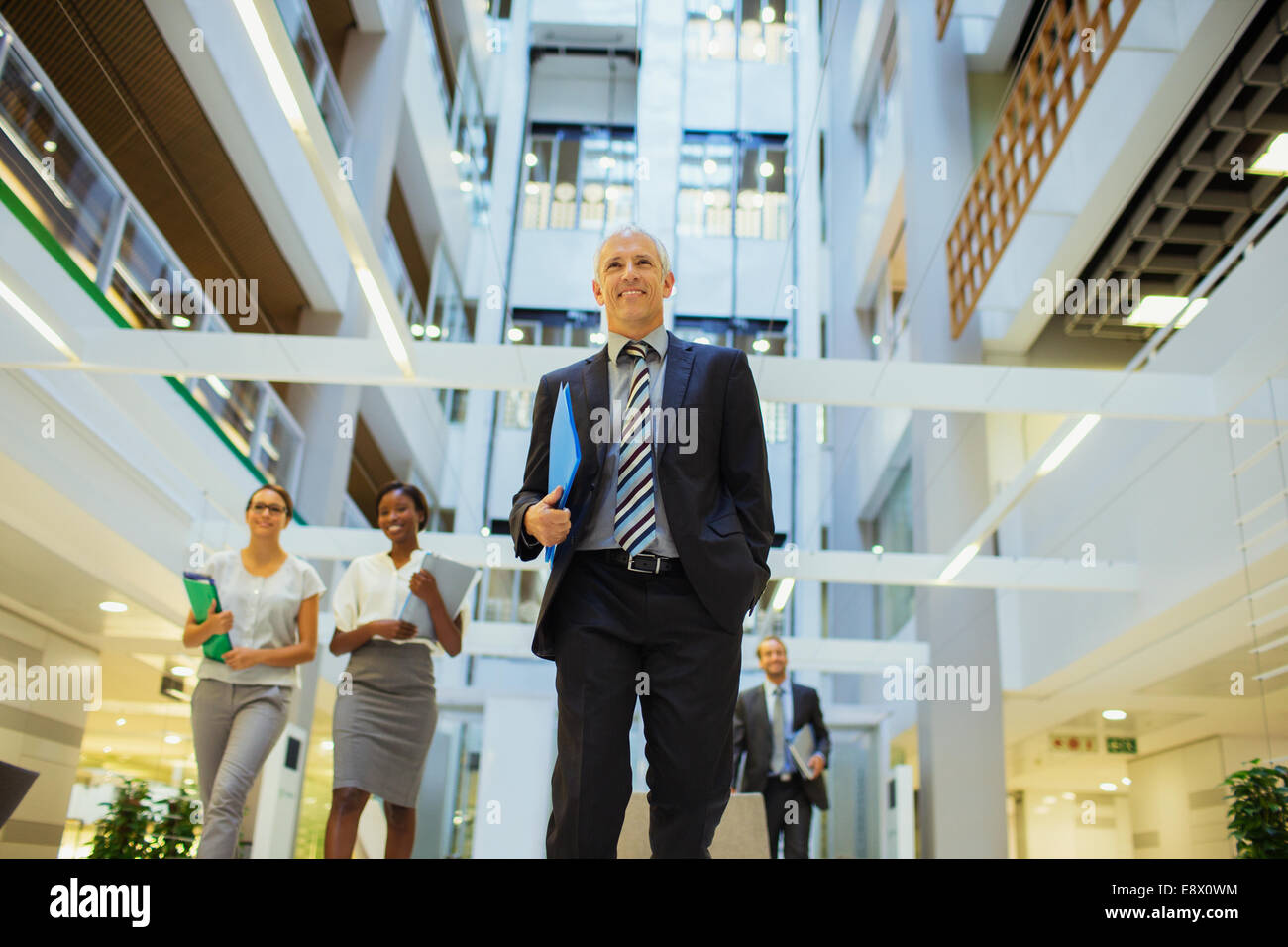 Business people walking through office building Stock Photo - Alamy