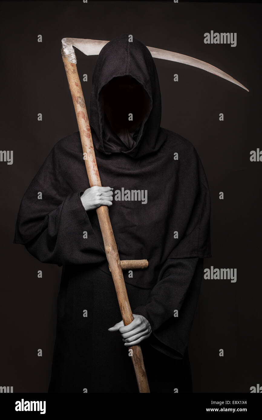 Angel of death with a scythe in his hands on black background. Halloween Stock Photo