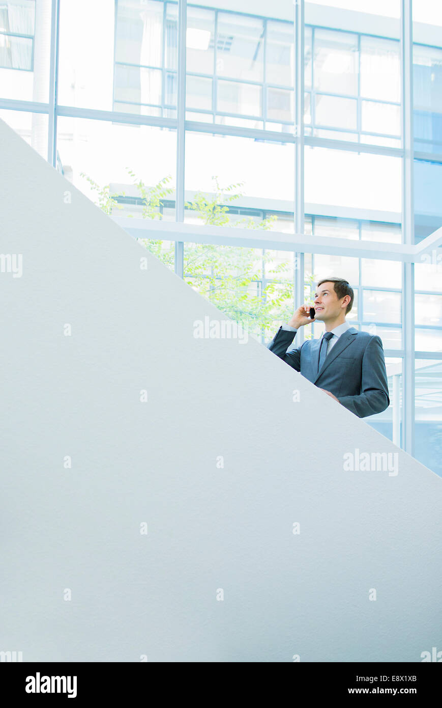 Businessman talking on cell phone on office stairs Stock Photo
