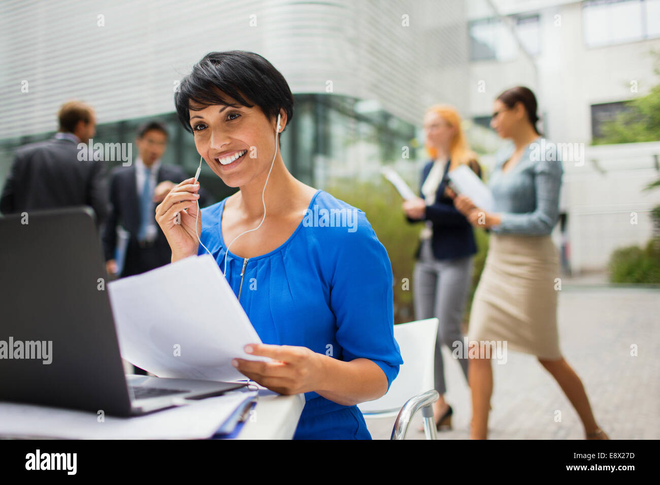Businesswoman talking on headset at table in office building Stock Photo