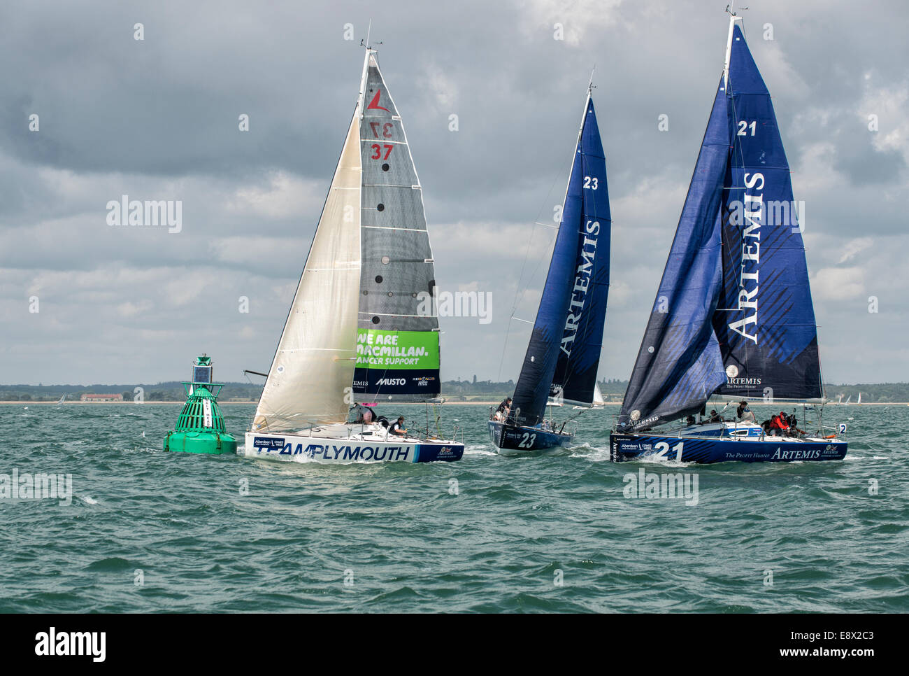 Close yacht racing as they round the buoy during the Cowes Week regatta in the Solent. Stock Photo