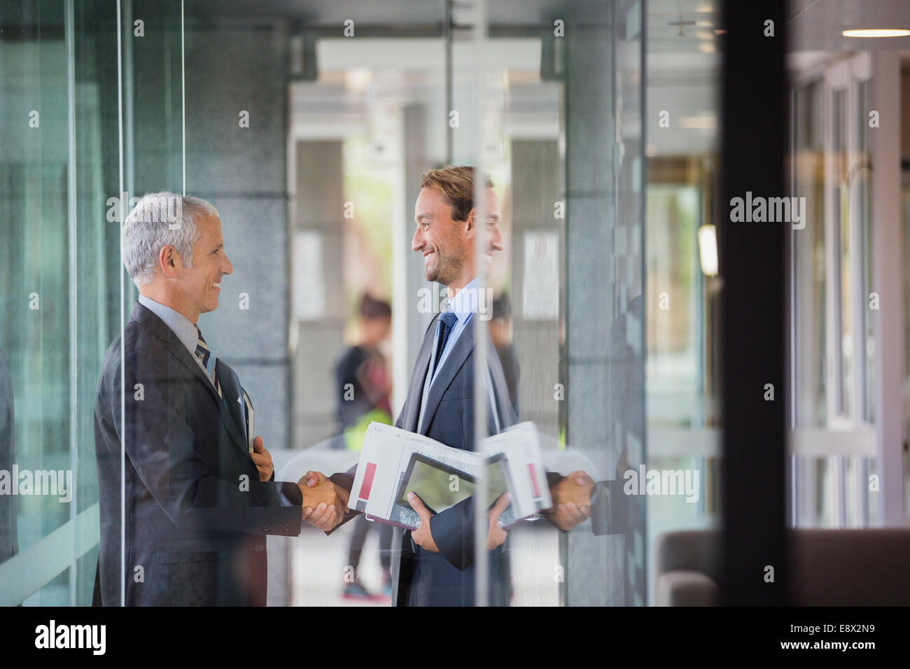Businessmen shaking hands in office building Stock Photo - Alamy