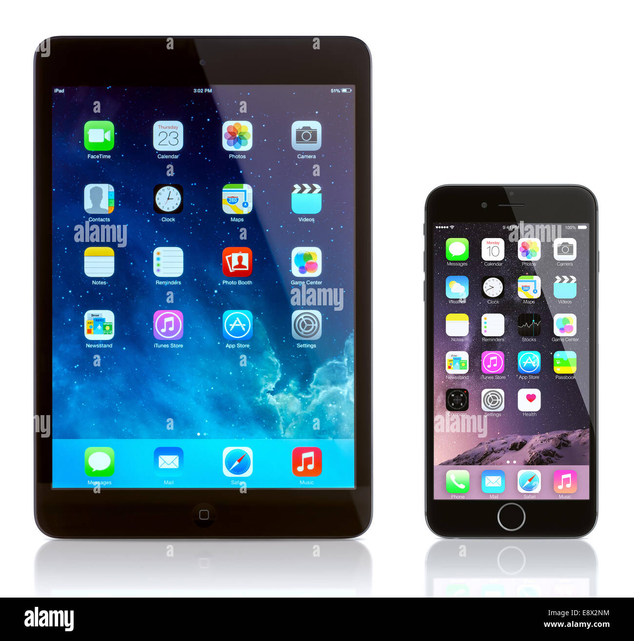 iPad Mini and iPhone 6 on white. Apple iOS 8 applications on the home screen of the iPhone. Stock Photo