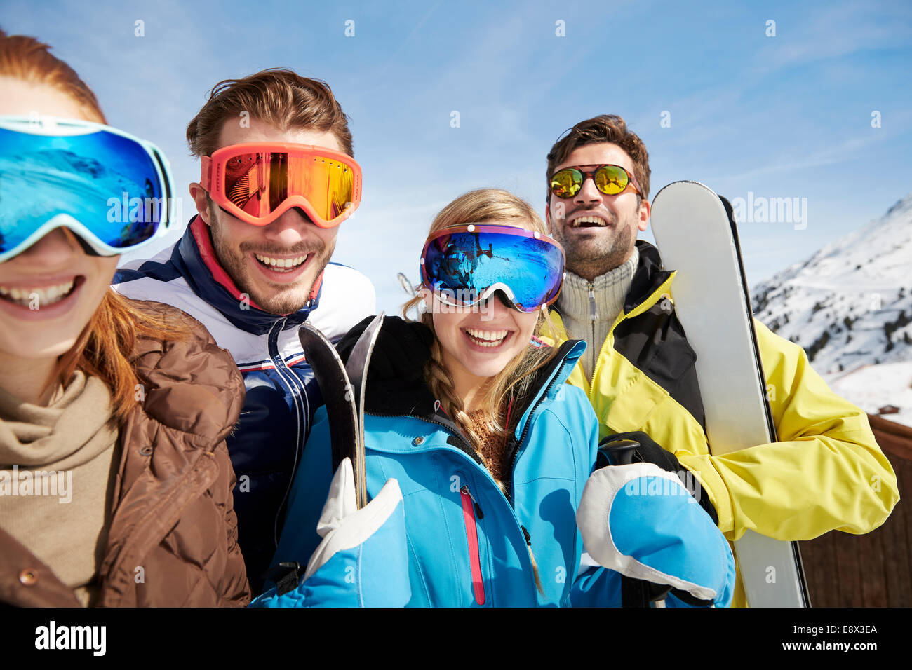 Friends carrying skis on mountain top Stock Photo