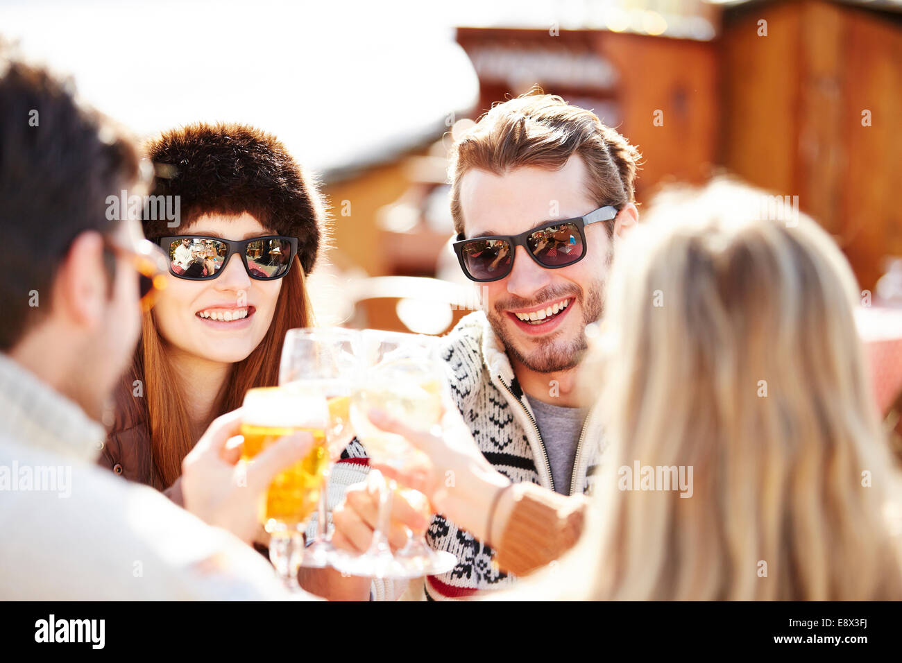 Friends celebrating with drinks in the snow Stock Photo