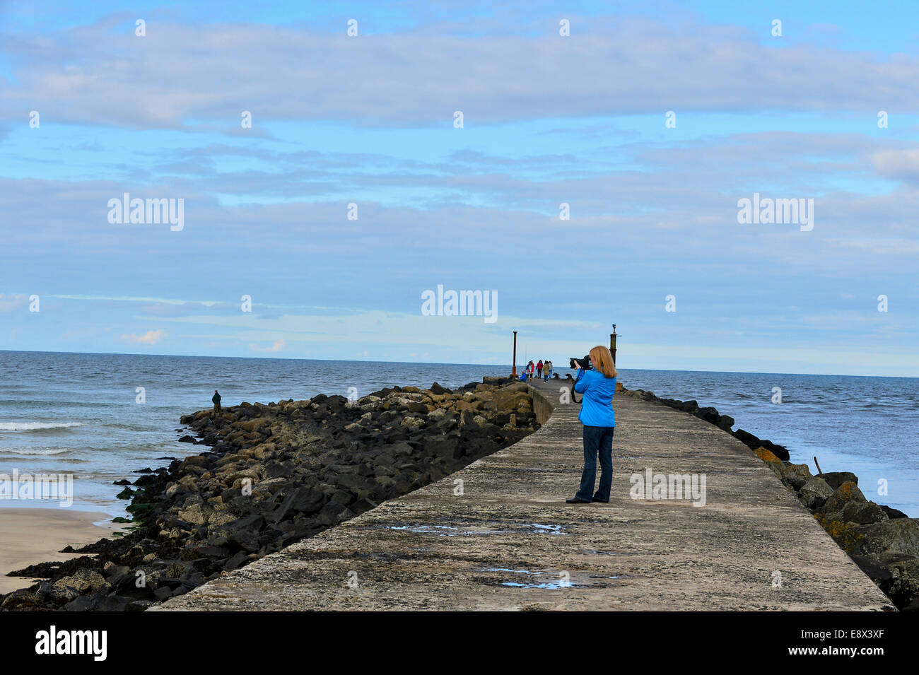 Stock Photo - Woman taking photographs from Castlerock Pier, County Derry, Londonderry, Northern Ireland. ©George Sweeney /Alamy Stock Photo