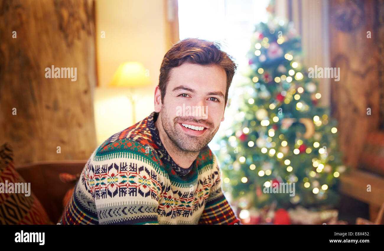 Man sitting on couch by Christmas tree Stock Photo