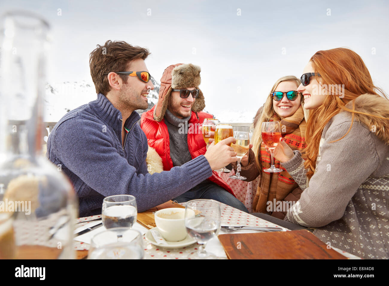 Friends celebrating with drinks in the snow Stock Photo