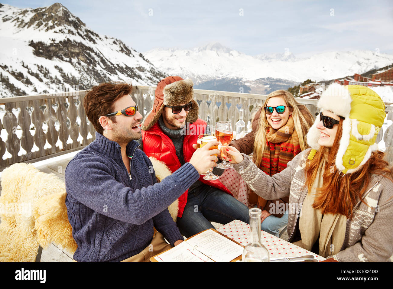 Friends celebrating with drinks in the snow Stock Photo