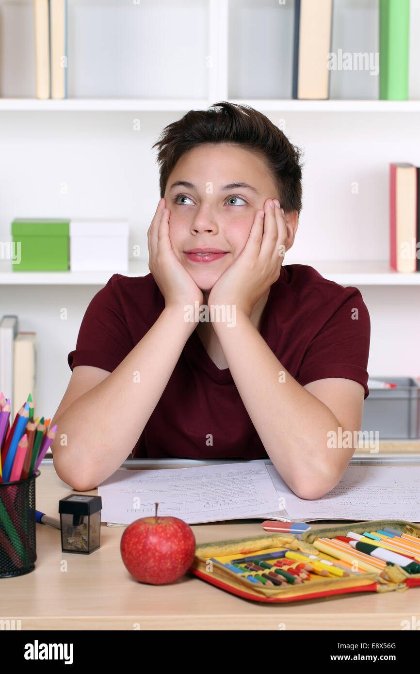 Young student day dreaming or relaxing at school while doing homework Stock Photo