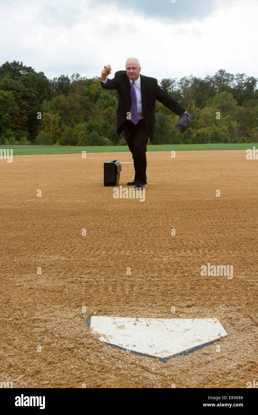 Businessman throwing a pitch on a baseball or softball playing field