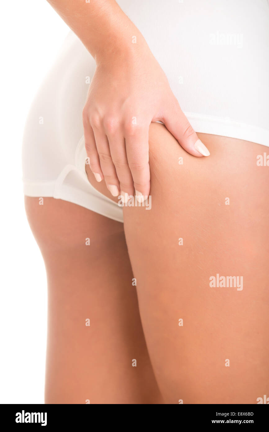 Closeup of woman examining her buttocks looking dor cellulite, isolated in white Stock Photo