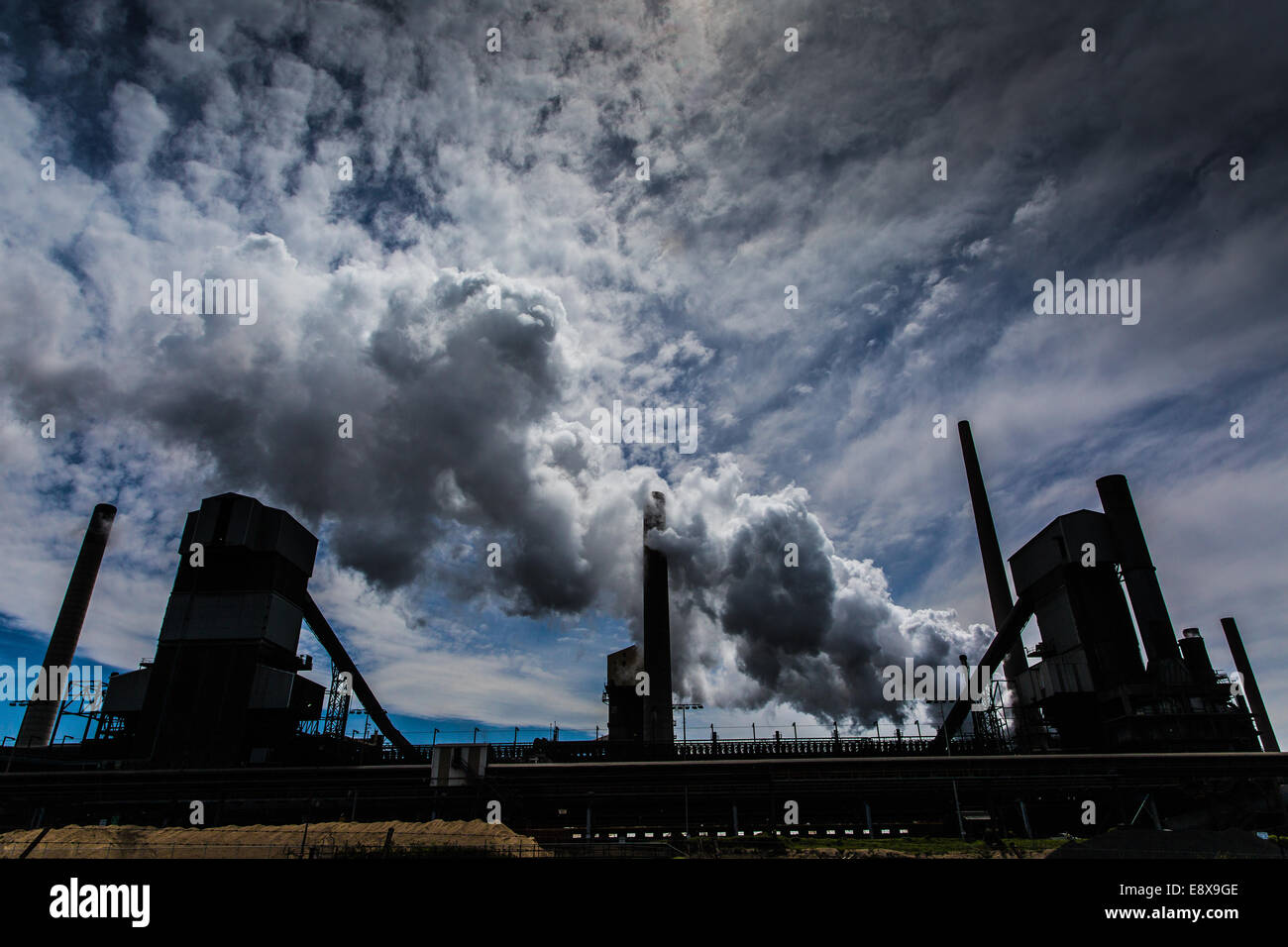 A steel mill in Australia emitting a plume of smoke or steam Stock Photo