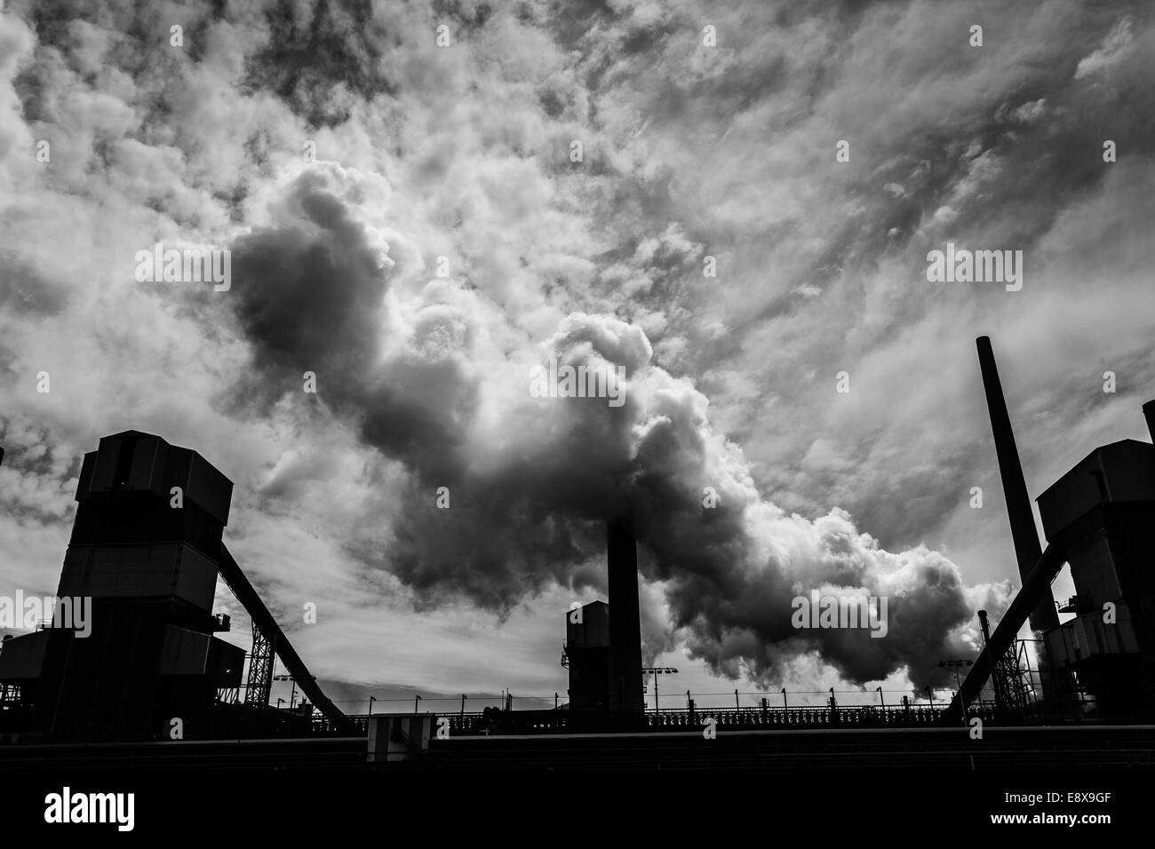 A steel mill in Australia emitting a plume of smoke or steam Stock Photo