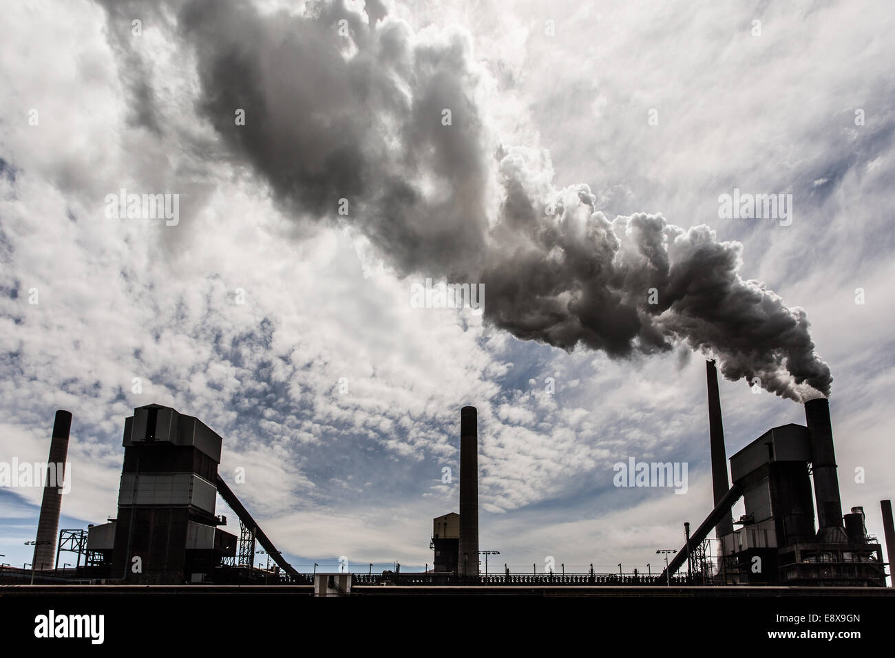 A steel mill in Australia emitting a plume of smoke or steam Stock Photo