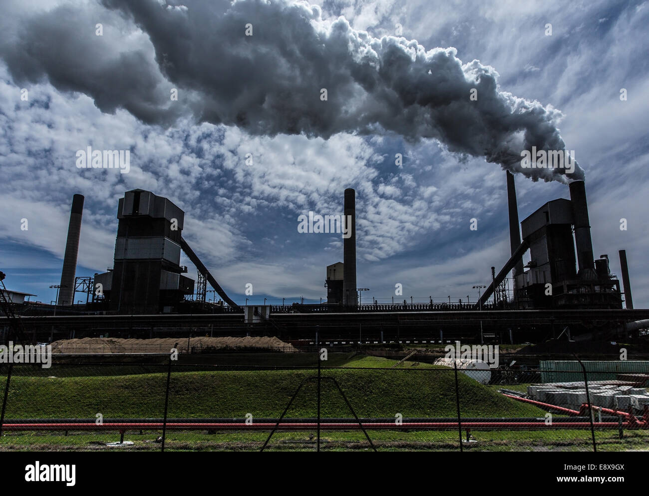 A steel mill in Australia emitting a plume of smoke or steam Stock Photo