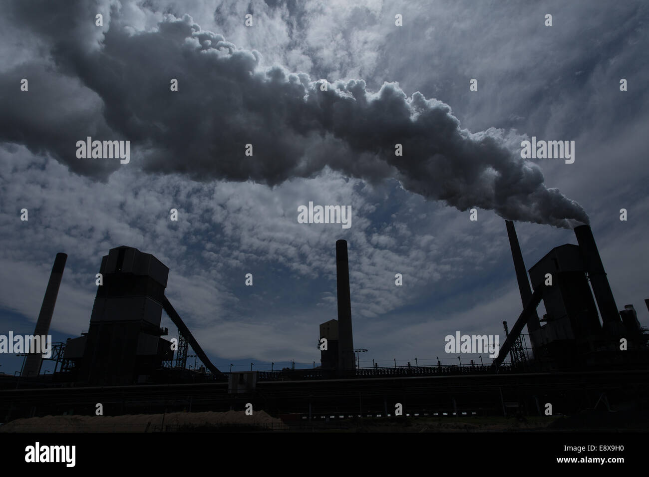 A steel mill in Australia emitting a plume of smoke or steam Stock Photo