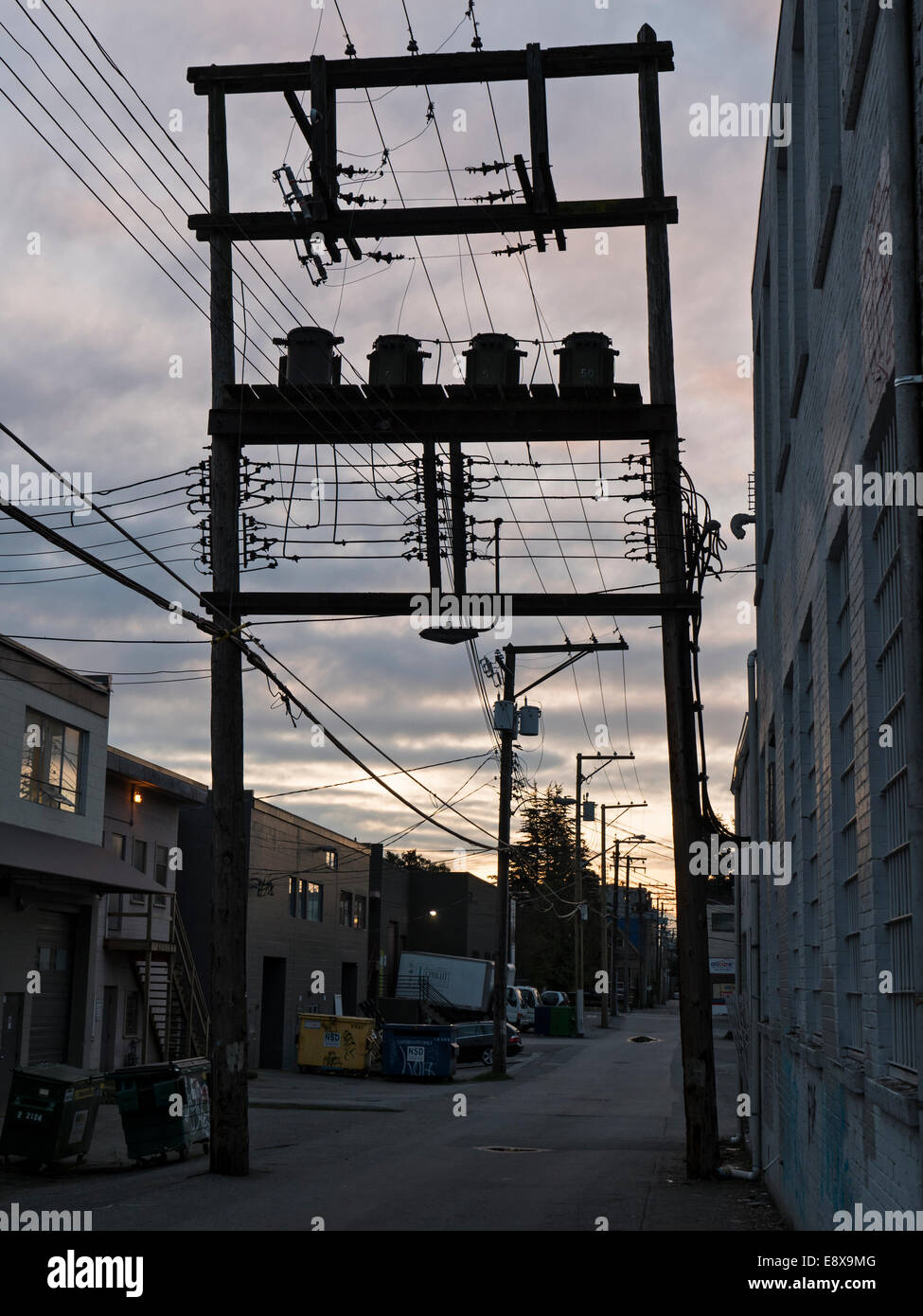 Silhouetted power poles and wires, part of a city's infrastructure, Vancouver, B.C., Canada. Stock Photo