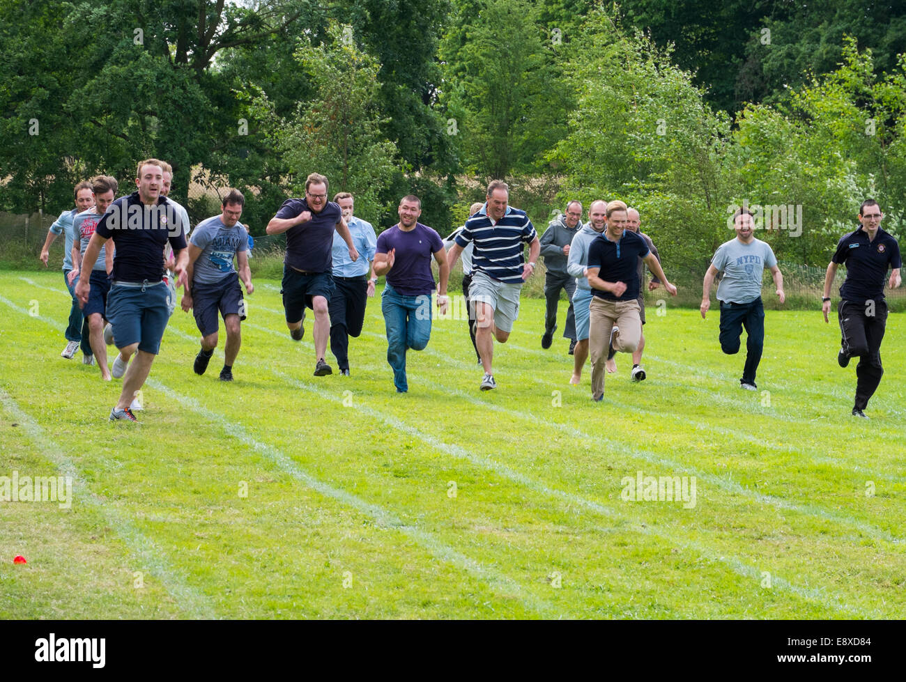 Dads competing in a parents race at a nursery school sports day Shropshire England Stock Photo
