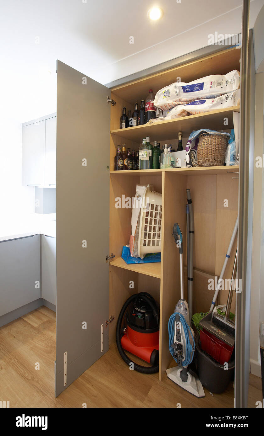 A cupboard with doors open in a utility room in a home in the Uk. Stock Photo
