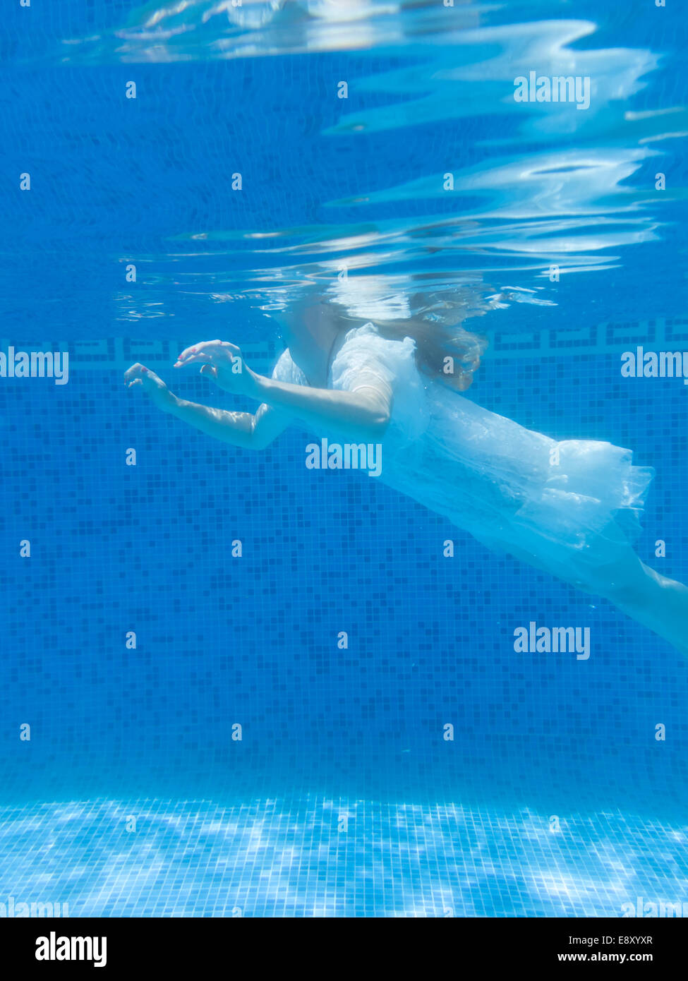 woman floating in a swimming pool Stock Photo