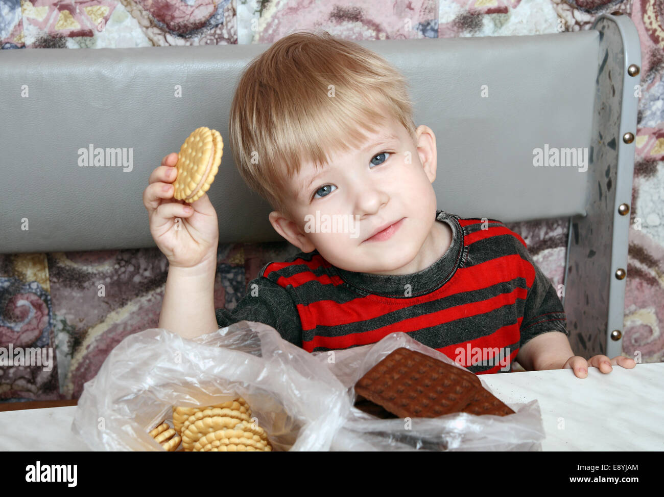 Handsome happy kid holding a biscuit Stock Photo