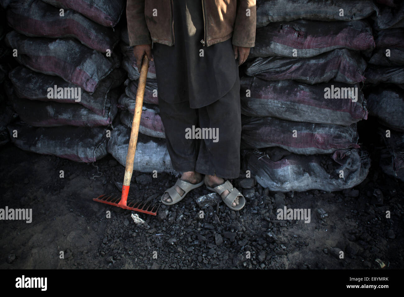Kabul, Afghanistan. 16th Oct, 2014. A laborer stands to have a rest at a coal market in Kabul, Afghanistan, Oct. 16, 2014. Afghan people are preparing fuel for the upcoming winter. © Ahmad Massoud/Xinhua/Alamy Live News Stock Photo