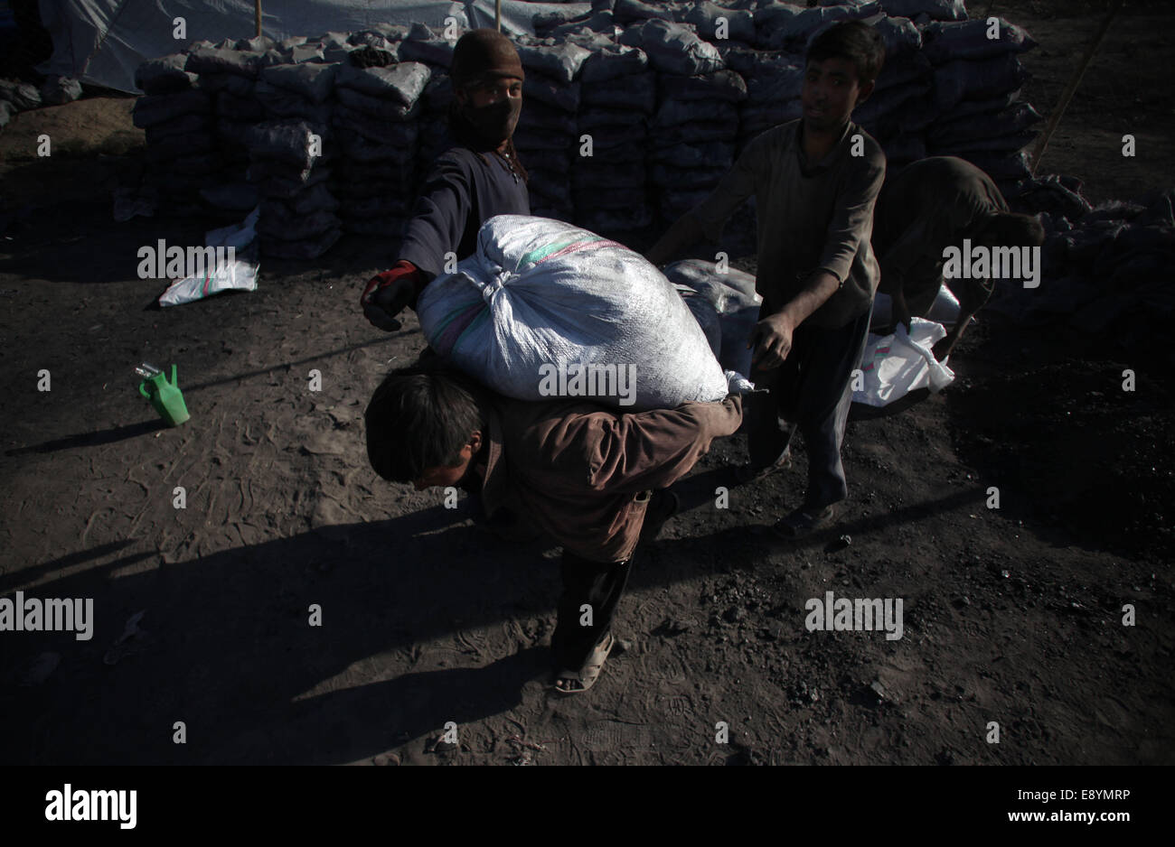 Kabul, Afghanistan. 16th Oct, 2014. A laborer carries a bag of coal at a coal market in Kabul, Afghanistan, Oct. 16, 2014. Afghan people are preparing fuel for the upcoming winter. © Ahmad Massoud/Xinhua/Alamy Live News Stock Photo
