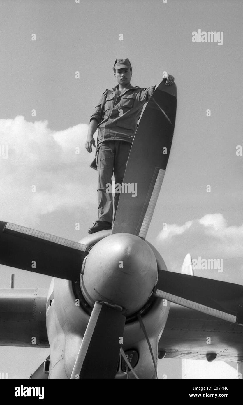 A soldier stands on the wing, near the turboprop of the military transport aircraft AN-24. Film scan. Large grain Stock Photo